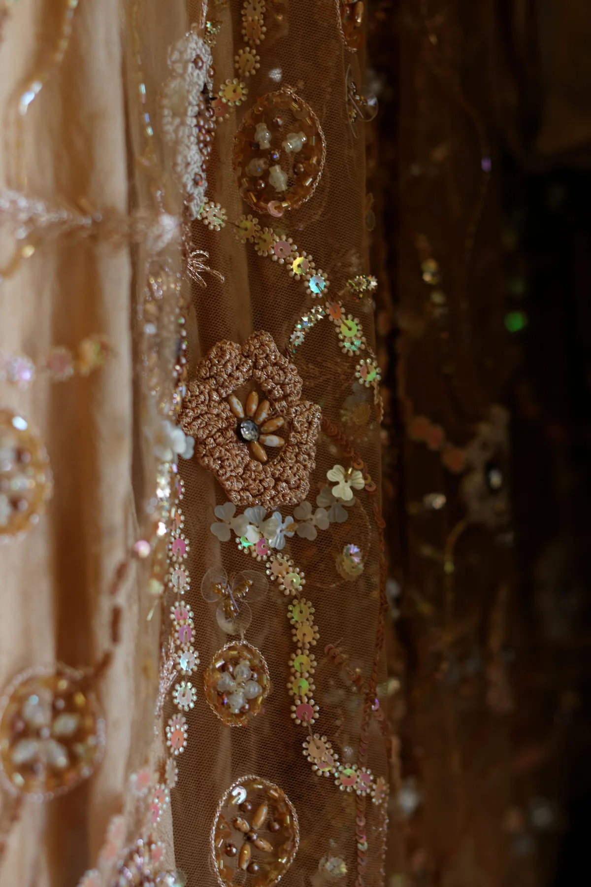 Floral ornaments and reflective details on translucent brown fabric.