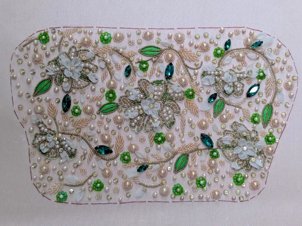 Shaped sample with green leaves, pale flowers and scattered rounded details inside a marked outline.