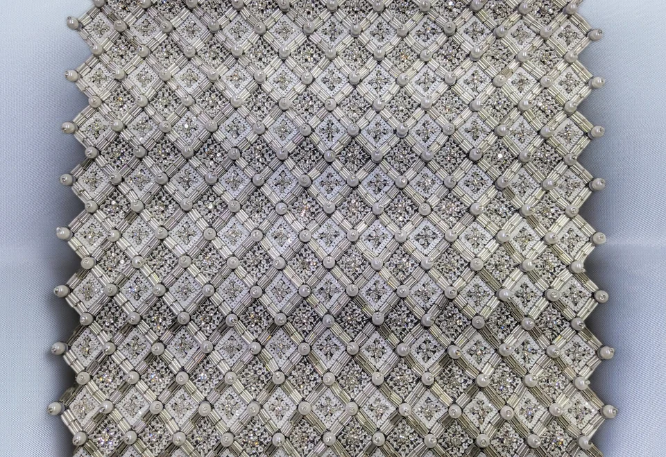 Pale diamond lattice with round accents at the intersections and fine details within each diamond.