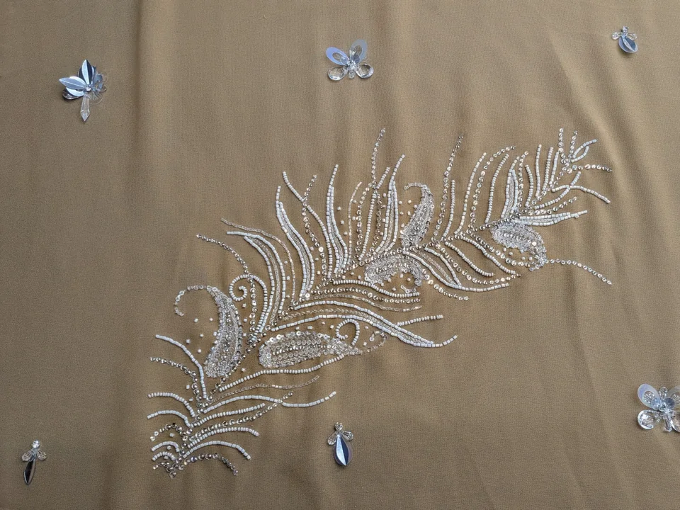 Fine reflective feather-like motif and small scattered accents on a beige ground.